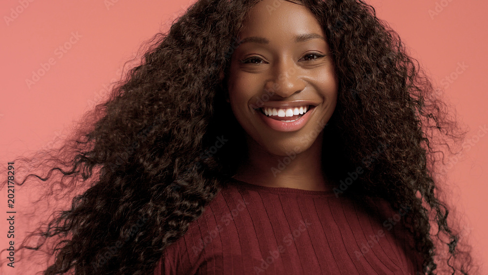Beauty mixed race african american woman with hair blowed in air smiling at camera Beauty mixed race african american woman with hair blowed in air smiling at camera