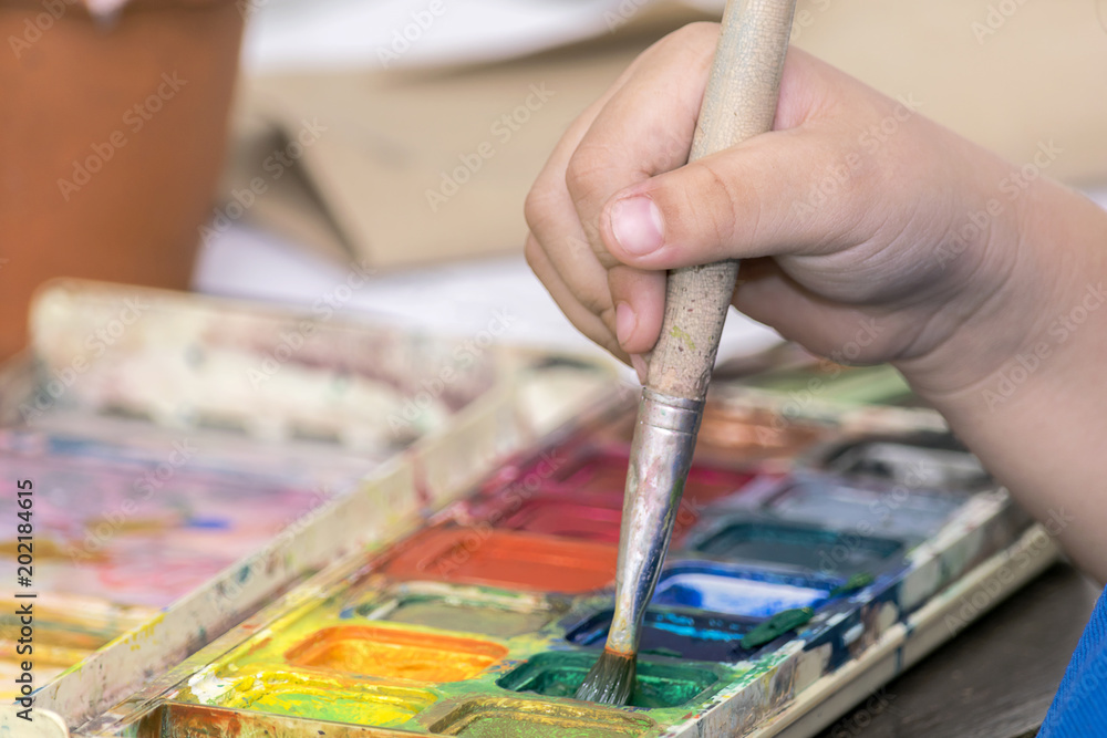 Obraz premium Baby hand catching paintbrush.