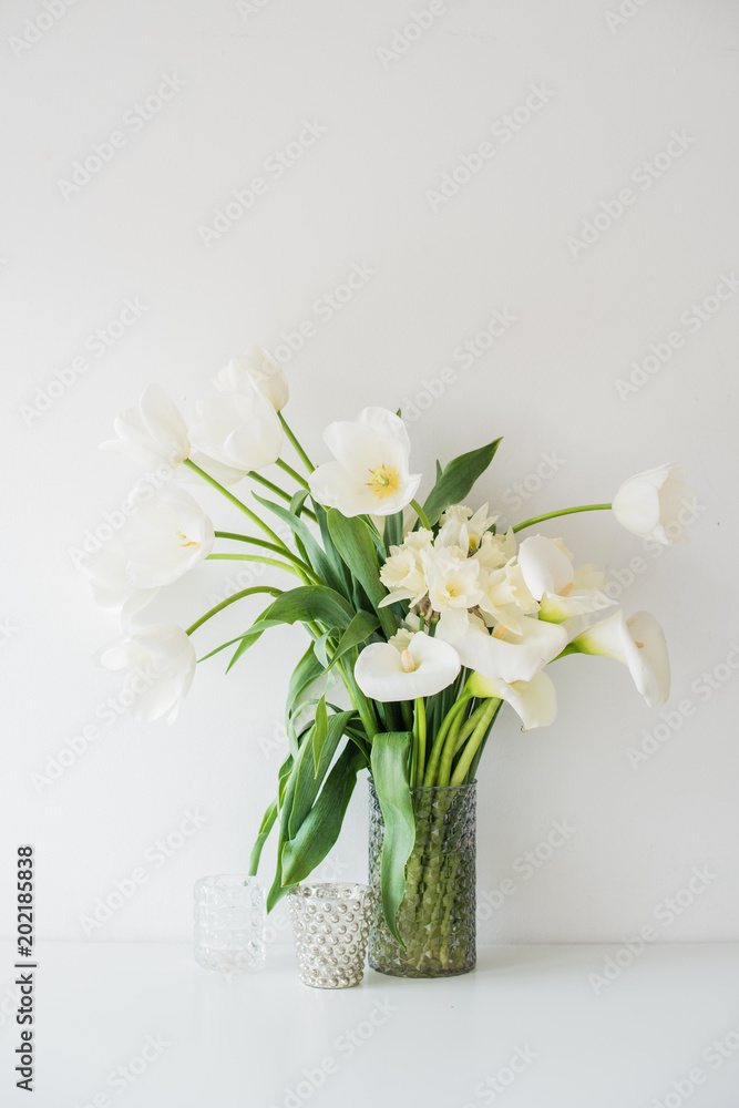 Large bouquet of white spring flowers in a vase, daffodils, tuli