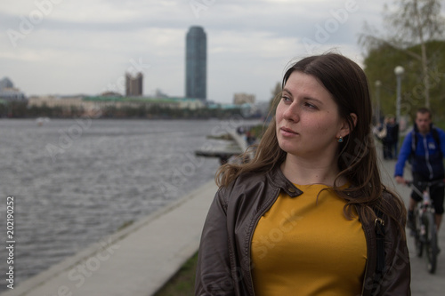 A young girl is standing on the waterfront of Yekaterinburg