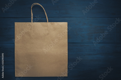 kraft paper package on a dark wooden table with a place for advertising