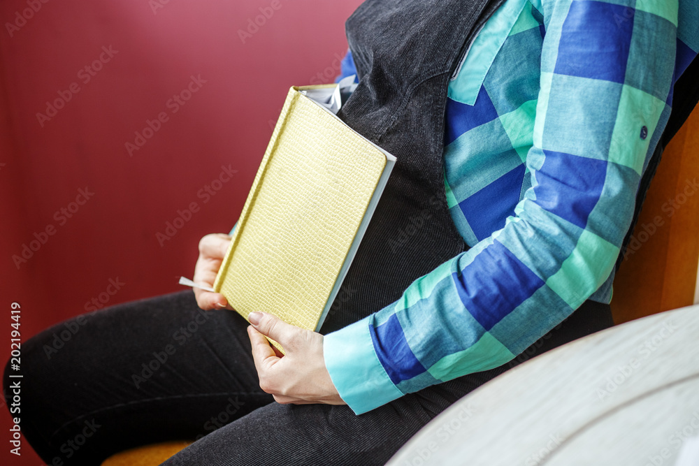 Obraz premium Pregnant woman with a book. Waiting for childbirth. Concept of life style, motherhood, reading, family.