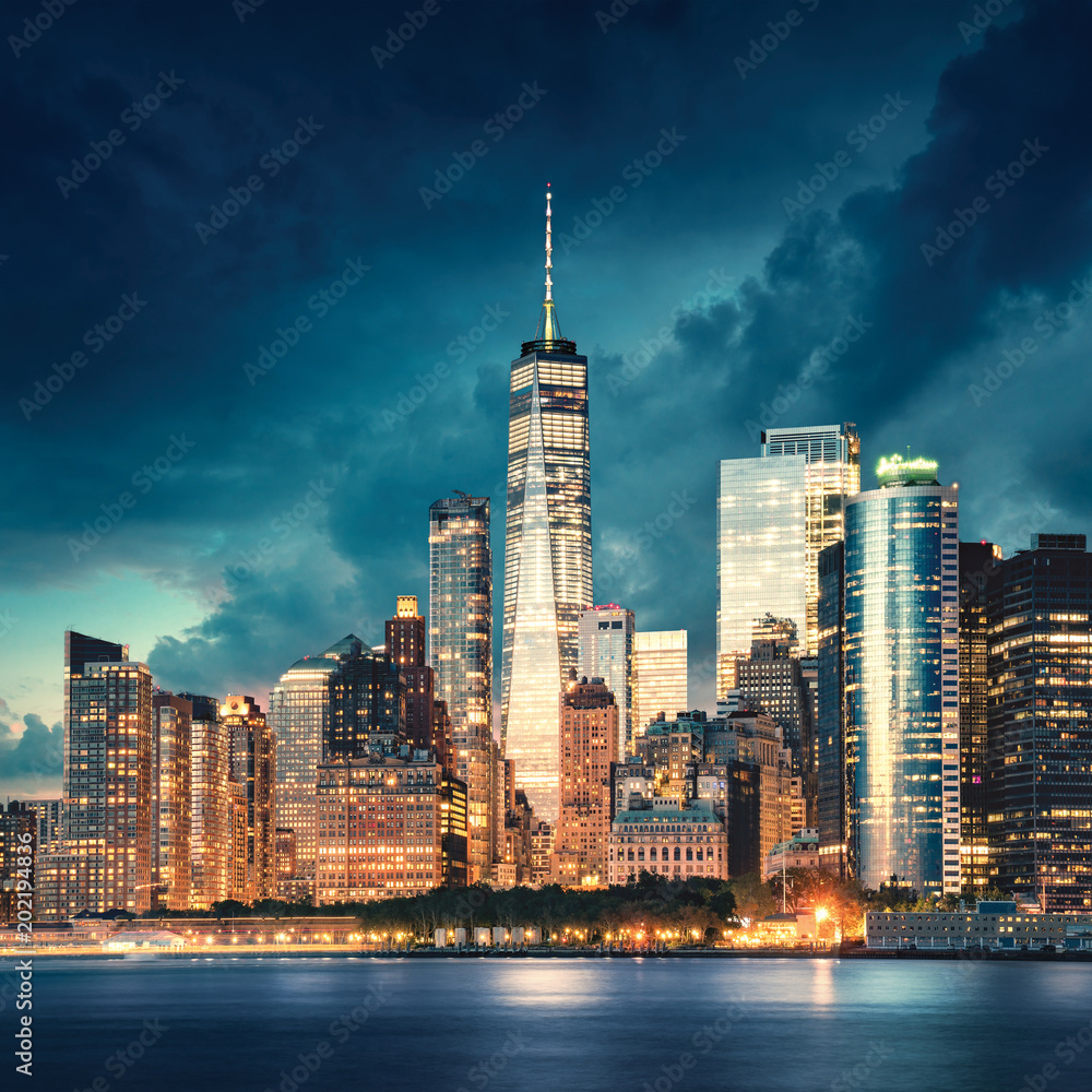 Obraz Miasto Nowy Jork Manhattan szczegół z drapaczami chmur przy dramatycznym zmierzchem. Rzeka i park nabrzeża z przodu. Zdjęcie zrobione z Governors Island.