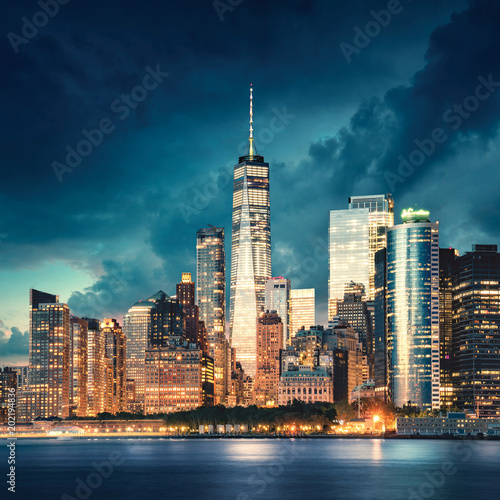 Obraz na płótnie Miasto Nowy Jork Manhattan szczegół z drapaczami chmur przy dramatycznym zmierzchem. Rzeka i park nabrzeża z przodu. Zdjęcie zrobione z Governors Island.