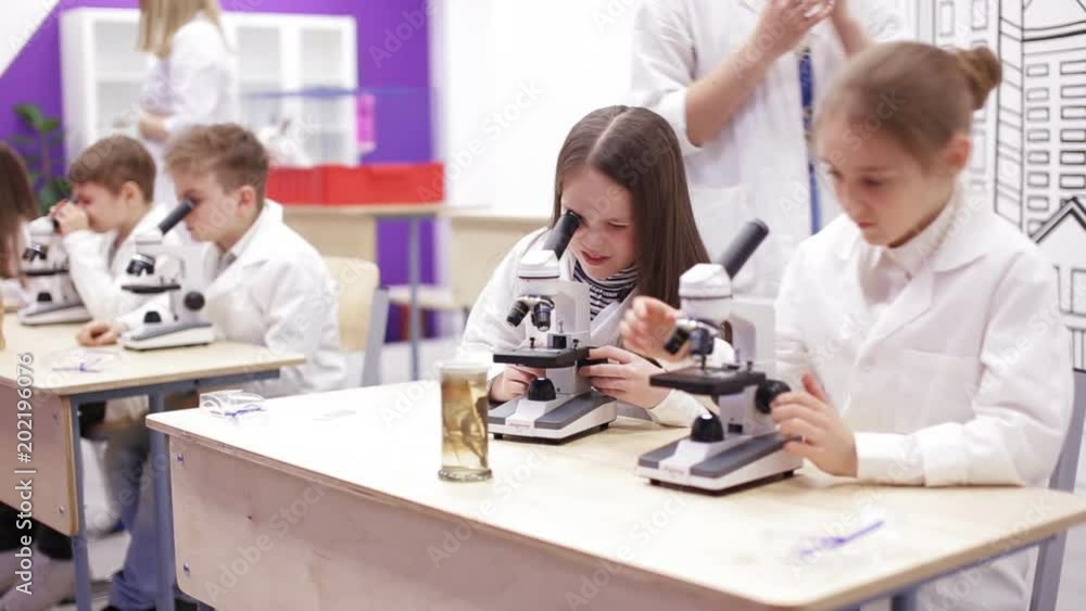 School children learn to work with a microscope School children learn to work with a microscope