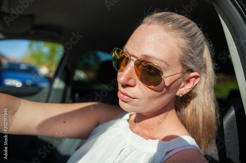 young woman with sunglasses in a car