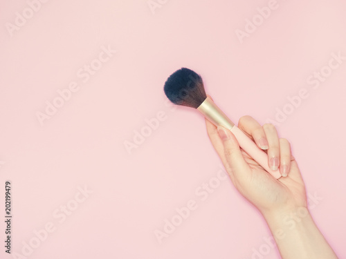 cosmetic and beauty concept from beauty asian hand hold and use cosmetic brush with isolated pink pastel background