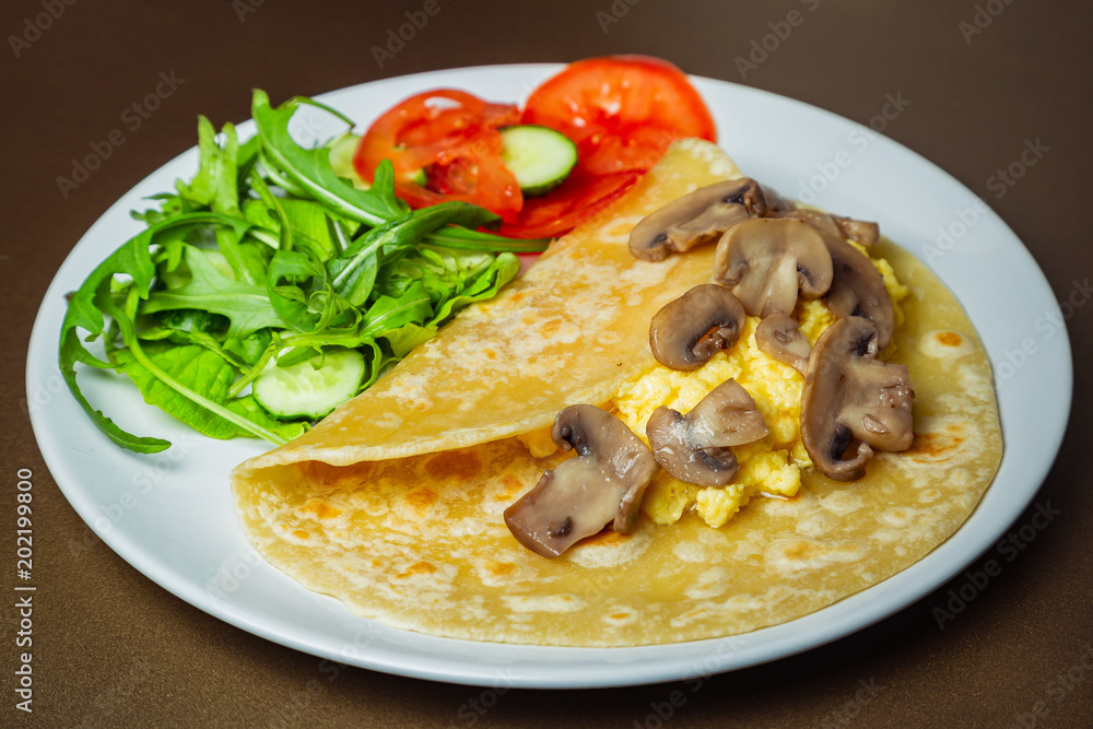 Scrambled eggs with mozzarella and champignon mushrooms on a white plate Scrambled eggs with mozzarella and champignon mushrooms on a white plate