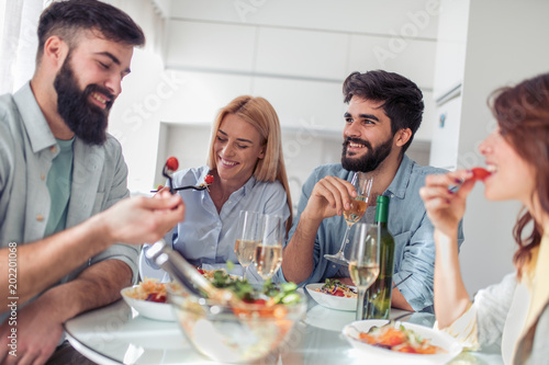 Positive happy young people enjoying food at home