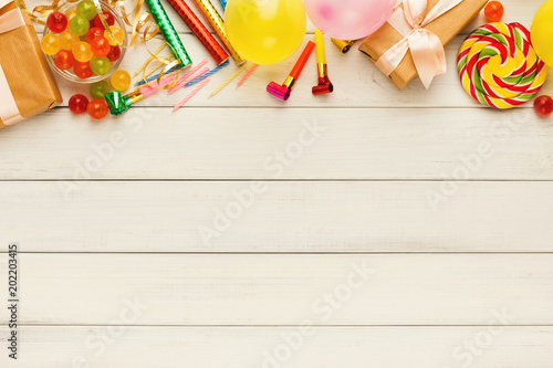 Colorful balloons on white rustic wood, birthday background, top