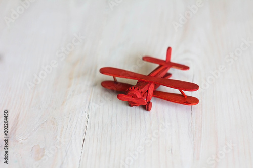 red toy airplane on light wooden background