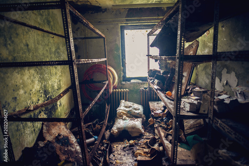 Ruined old forgotten room with mess and shelves in disorder in the abandoned deserted house.