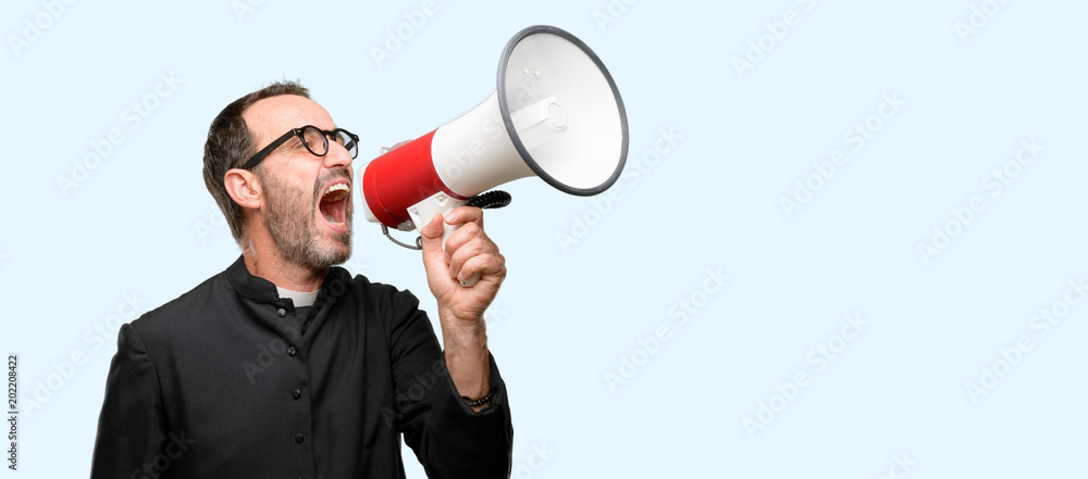 Priest religion man communicates shouting loud holding a megaphone, expressing success and positive concept, idea for marketing or sales isolated over blue background Priest religion man communicates shouting loud holding a megaphone, expressing success and positive concept, idea for marketing or sales isolated over blue background