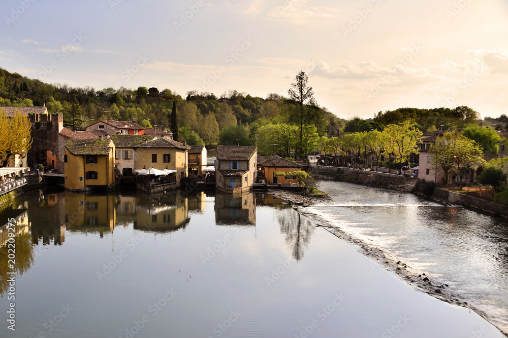 Fototapeta premium Il paesino di Borghetto sul Mincio,si rispecchia tranquillo nelle calme acque del fiume.