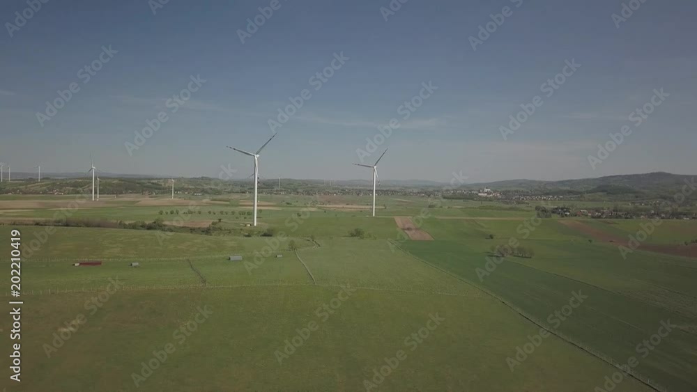 Flight near a wind power station in the daytime in the spring. Rotating blades of energy generators. Ecologically clean electricity. Modern technologies for the use of natural resources. Flight near a wind power station in the daytime in the spring. Rotating blades of energy generators. Ecologically clean electricity. Modern technologies for the use of natural resources.