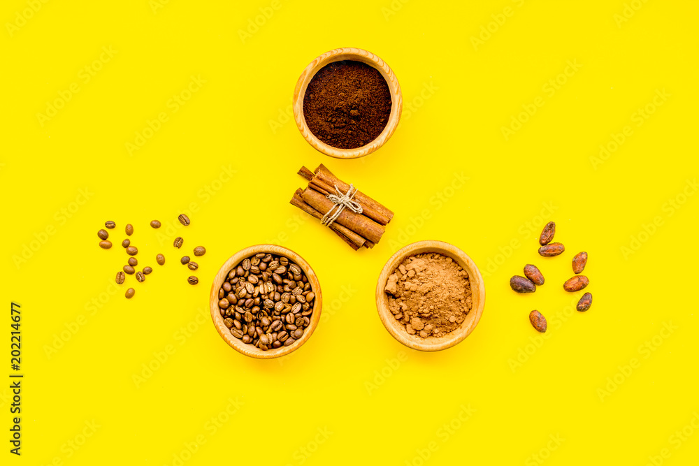 Fototapeta premium Ingredients for bakery and desserts. Cinnamon, cocoa, coffee, sugar, spices on yellow background top view