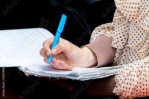 Girl student with a pen in his hand notes important information while preparing to take the exam_