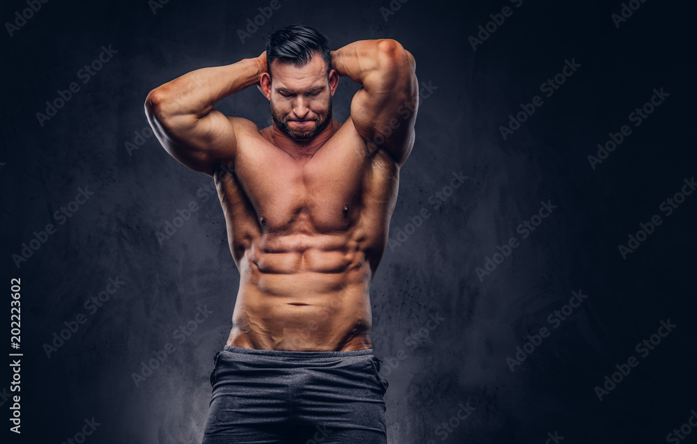 Portrait of a shirtless tall huge male with a muscular body with a stylish  haircut and beard, in a sports shorts, standing in a studio. Photos | Adobe  Stock