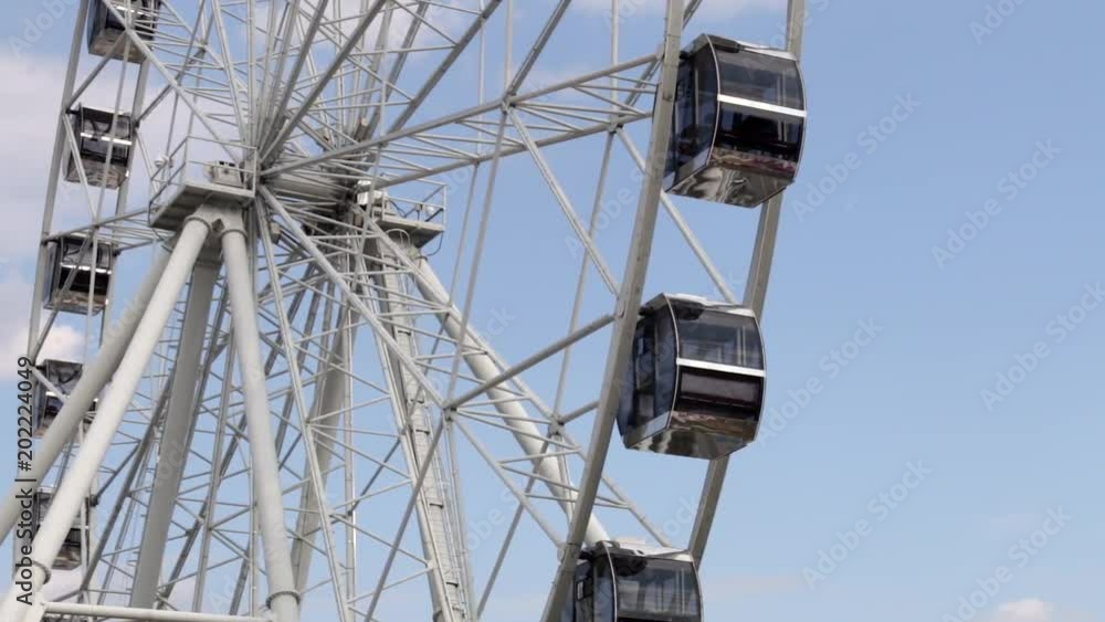 Cabins Ferris Wheel rotating on a cloudy sky background. Cabins Ferris Wheel rotating on a cloudy sky background.
