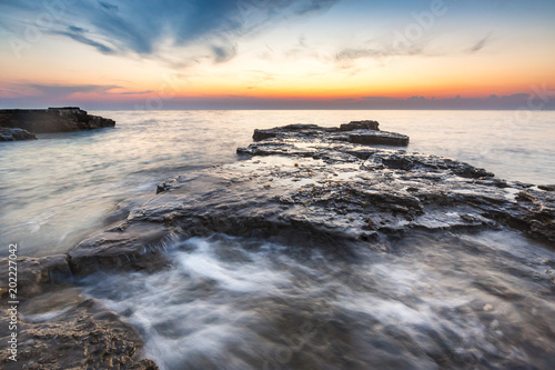 Enjoying the colorful sunset on a beach with rocks on the Adriatic Sea coast Istria Croatia