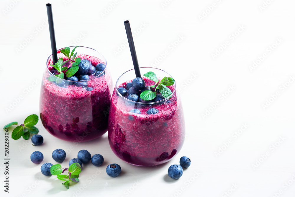 Freshly squeezed blueberry juice on the table. a healthy summer drink in two glasses. Freshly squeezed blueberry juice on the table. a healthy summer drink in two glasses.