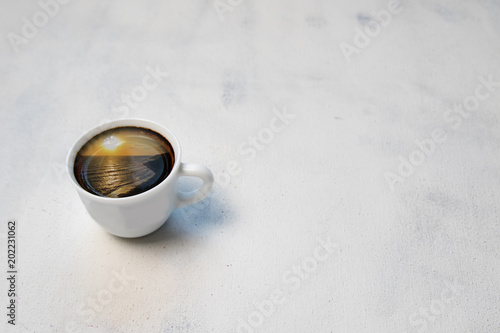 Ocean or sea in cup.Cup of coffee with the sea inside on white vintage table.