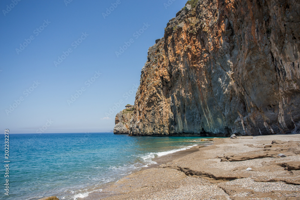 Fototapeta premium Summer travel concept. Beautiful beach with rocky shore.