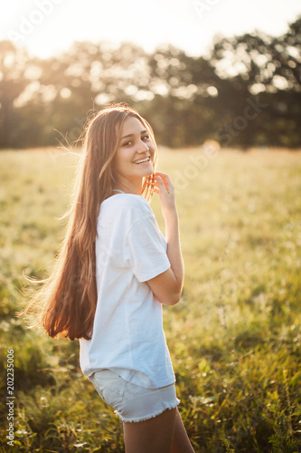 Young attractive female walking outdoors at sunset