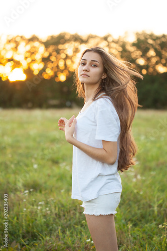Young woman walking outdoors at sunset