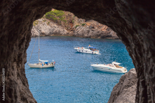 View through a hole in the rock on yachts and boats in the bay The island of Mallorca. Spain © DMITRIY