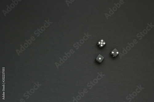 three black dice on a dark cloth, space for text