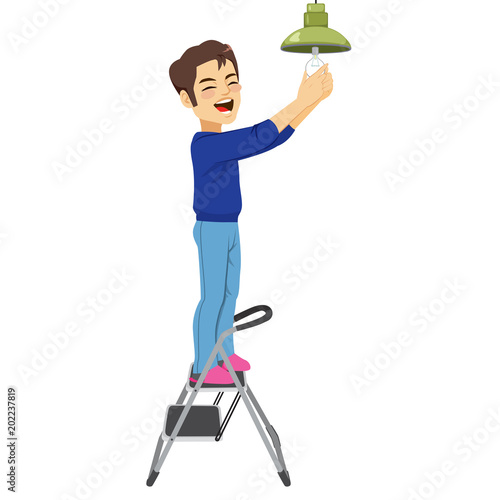 Young happy man changing light bulb with ladder