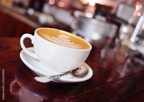 a cup of coffee with a pattern on a foam or latte-art close-up on a coffee house background