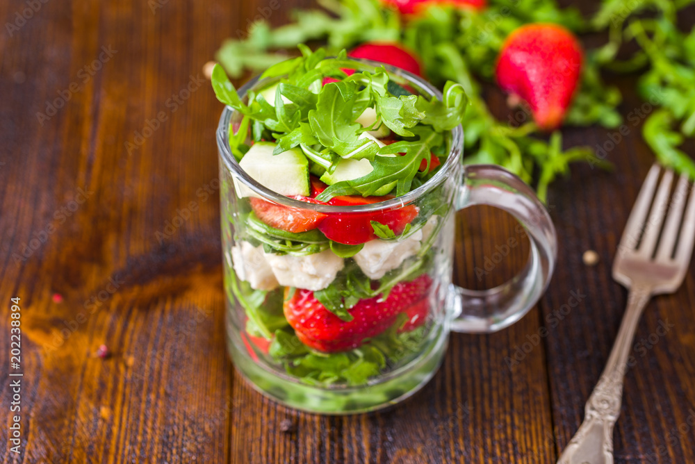 Fresh vegetable strawberry salad in glass jar on natural rustic desk. Fresh vegetable strawberry salad in glass jar on natural rustic desk.