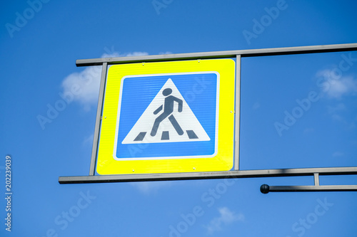 Pedestrian Crossing sign on street over blue sky