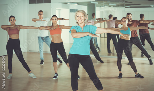 positive men women posing in fitness studio