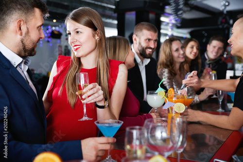 Woman and her boyfriend with cocktails having fun at nightclub