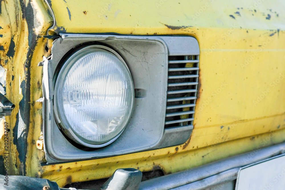 Headlight of yellow old rusty retro car