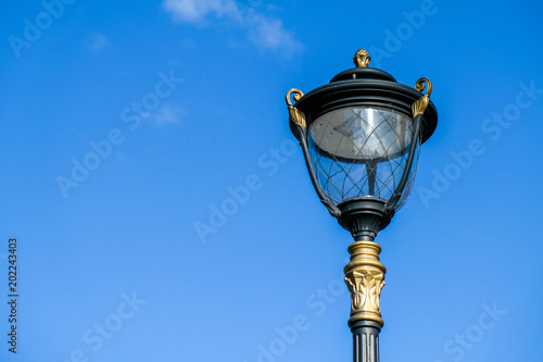 Vintage lamp post close-up over blue sky