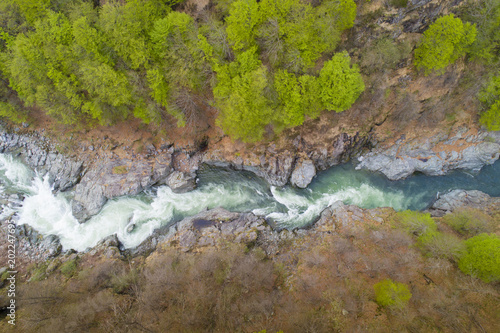 Mountain river flowing in a canyon, bird view, perspective from above, aerial drone shot.