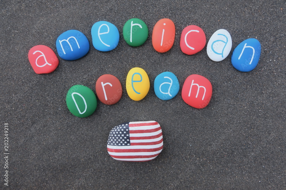 American dream text composed with multicolored stones over black volcanic sand