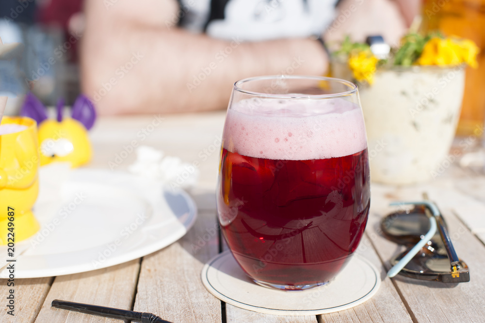 Cafe and sunlight. A glass of Belgian fruit beer. Alcohol on the table Cafe and sunlight. A glass of Belgian fruit beer. Alcohol on the table