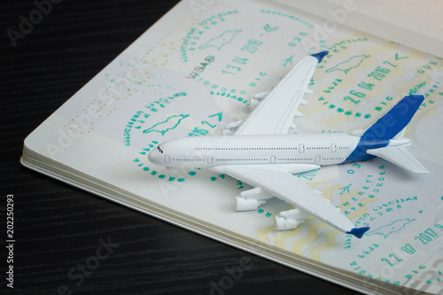Airplane and open passport with a visa. Close up