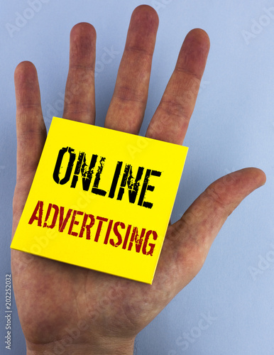 Writing note showing  Online Advertising. Business photo showcasing website campaigns Ads electronic marketing SEO Reaching written on Sticky Note Paper on the plain blue background Hand.