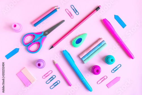 Pink desk with variety of rose and blue school supplies. Back to school minimalism concept. Top view
