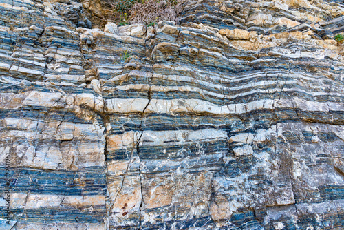 Compressed rock layers formation in various colors and thicknesses, on south central coast of the  Mediterranean island Crete, Greece. Nature and Geological science concept photo