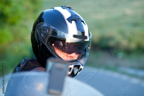 close up portrait of rider on a motorcycle - summer road trip on a motorbike