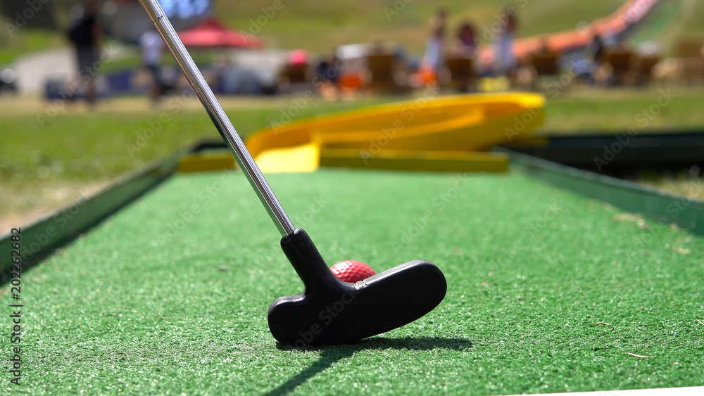 Closeup of player play mini golf with red ball - obrazy, fototapety, plakaty 