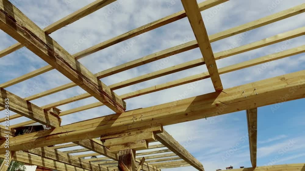 New construction home framing against a blue sky and sun New construction home framing against a blue sky and sun