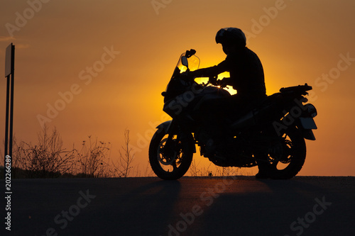 silhouette of rider on a motorbike admiring sunset - space for your text © Melinda Nagy